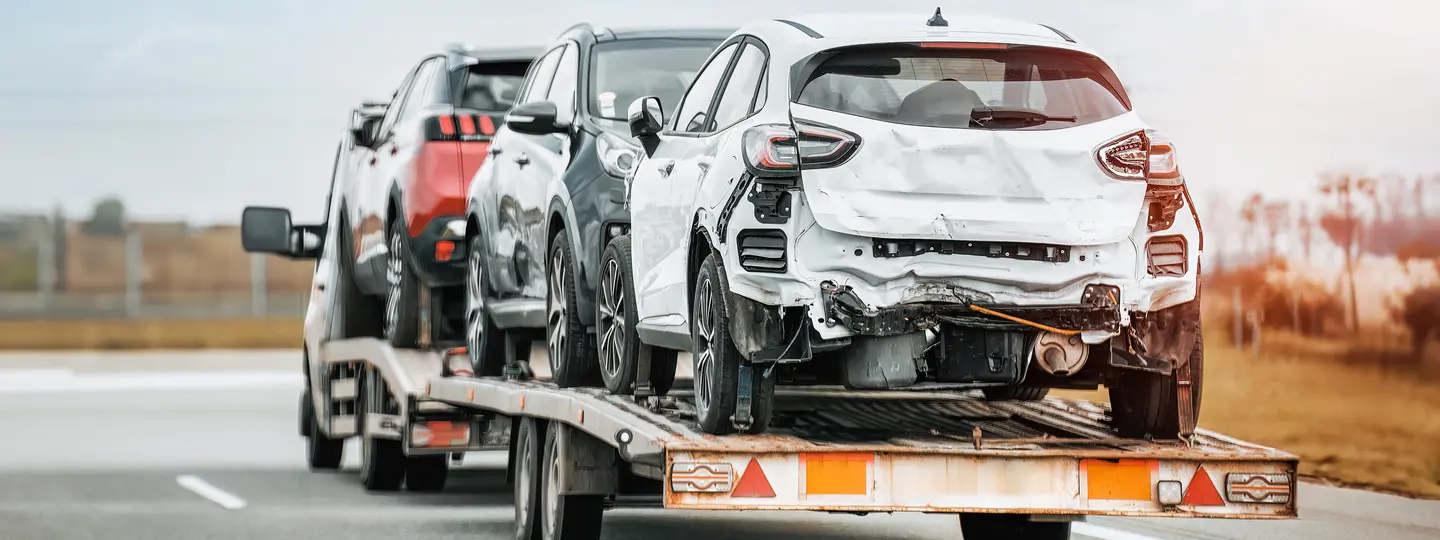 Abschleppwagen transportiert beschädigte Autos auf Autobahn