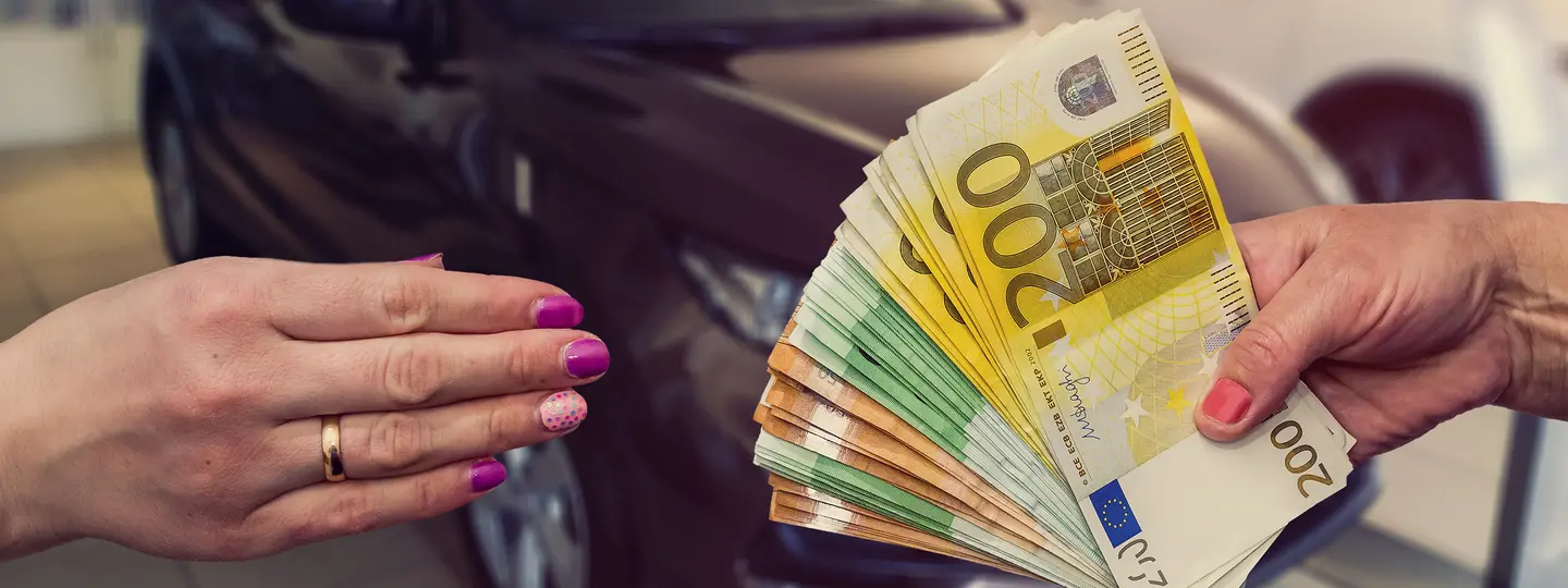 Autohändler händigt Euro Scheine an Kunden bei Autoankauf