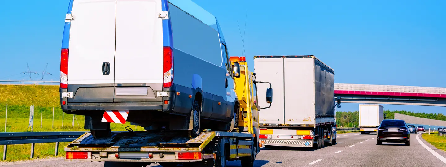 Autohändler transportiert Nutzfahrzeug auf Abschleppwagen