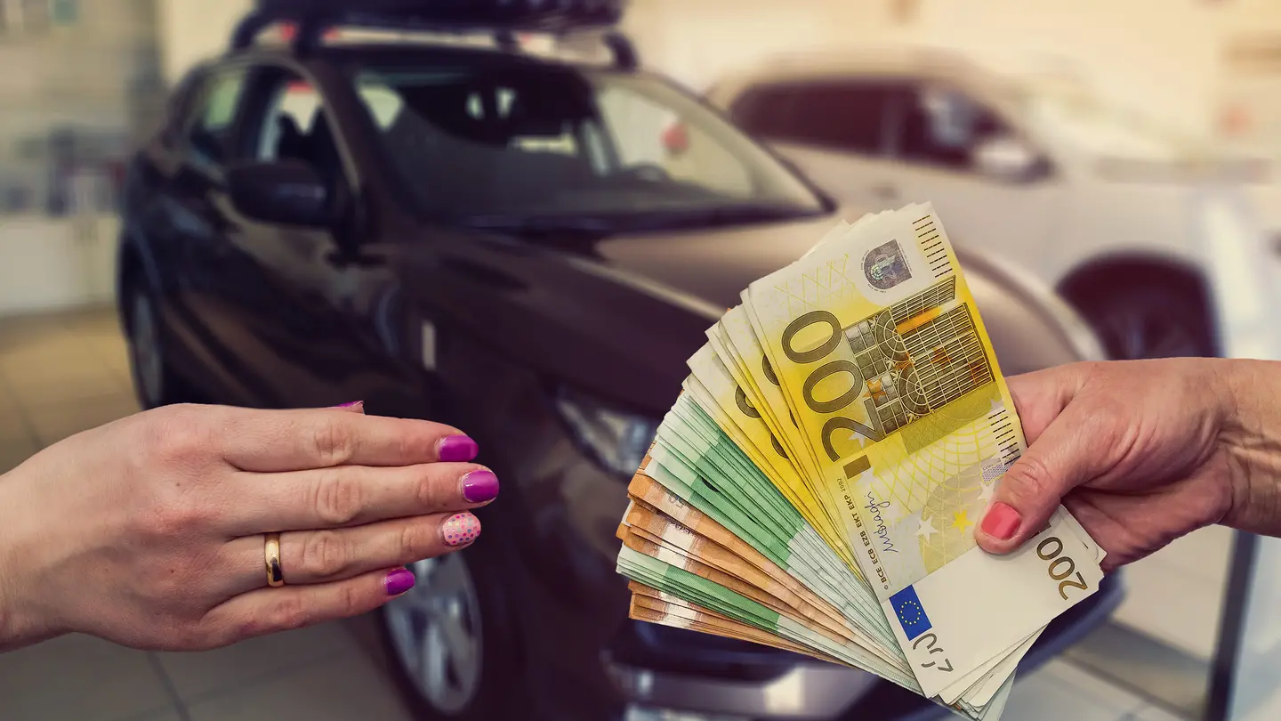 Autohändler übergibt Bargeld an Autoverkäufer