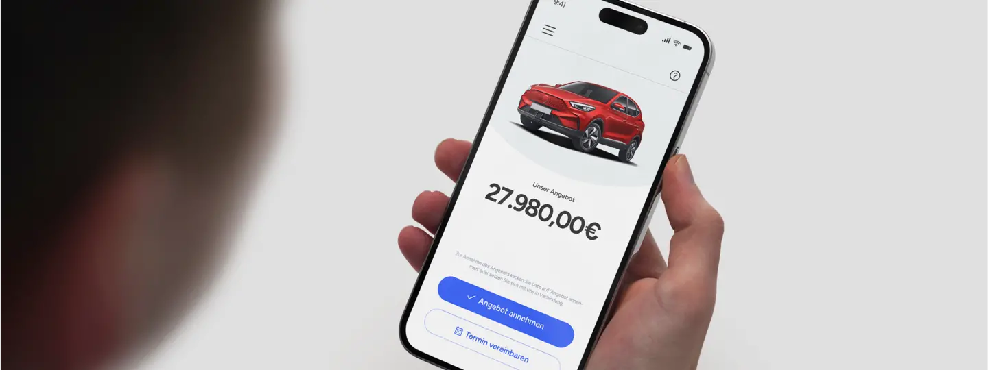 Mann schaut auf Samrtphone mit Kaufpreisangebot für Gebrauchtwagen